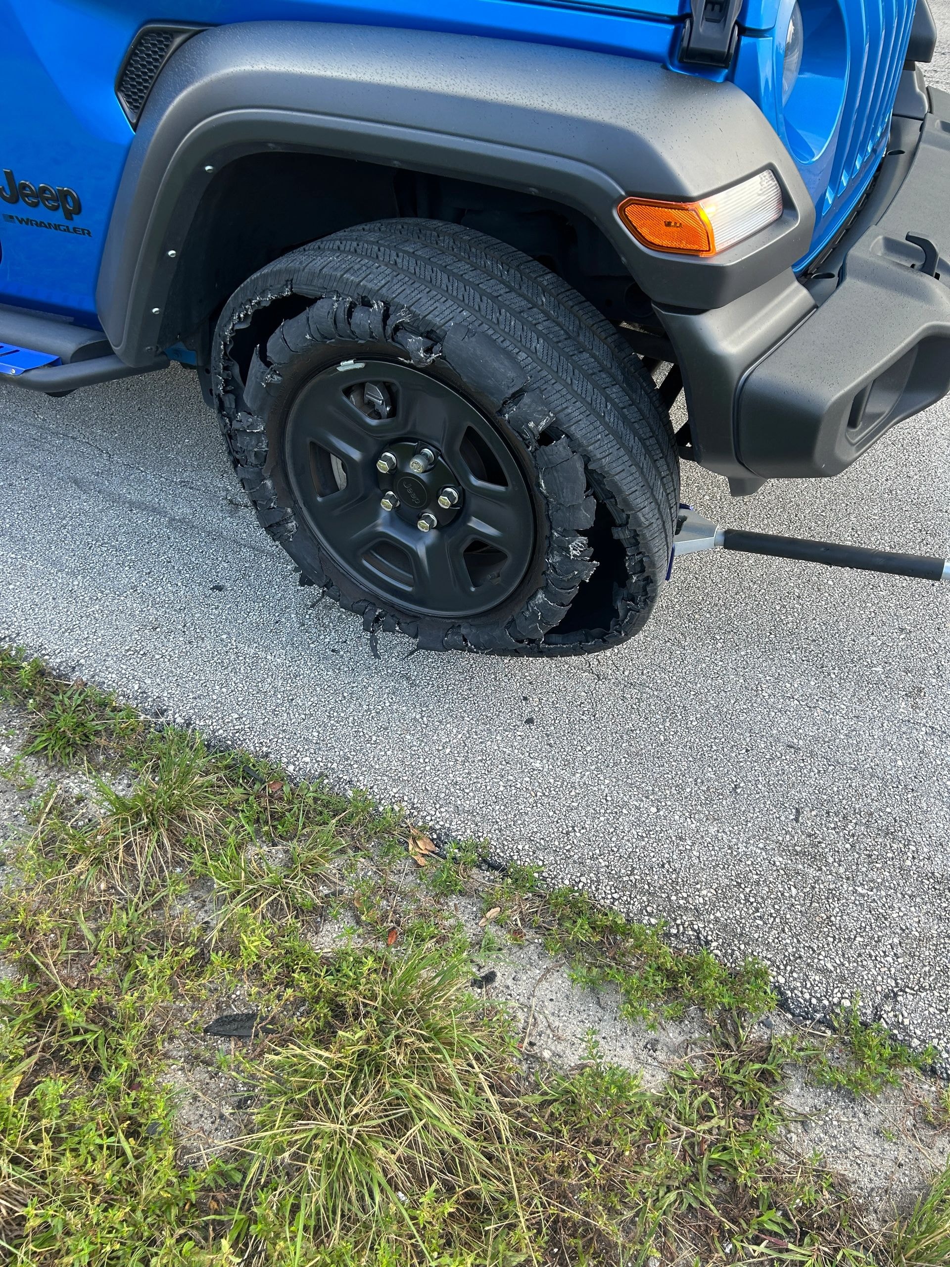 Blue Jeep with black all-terrain tire