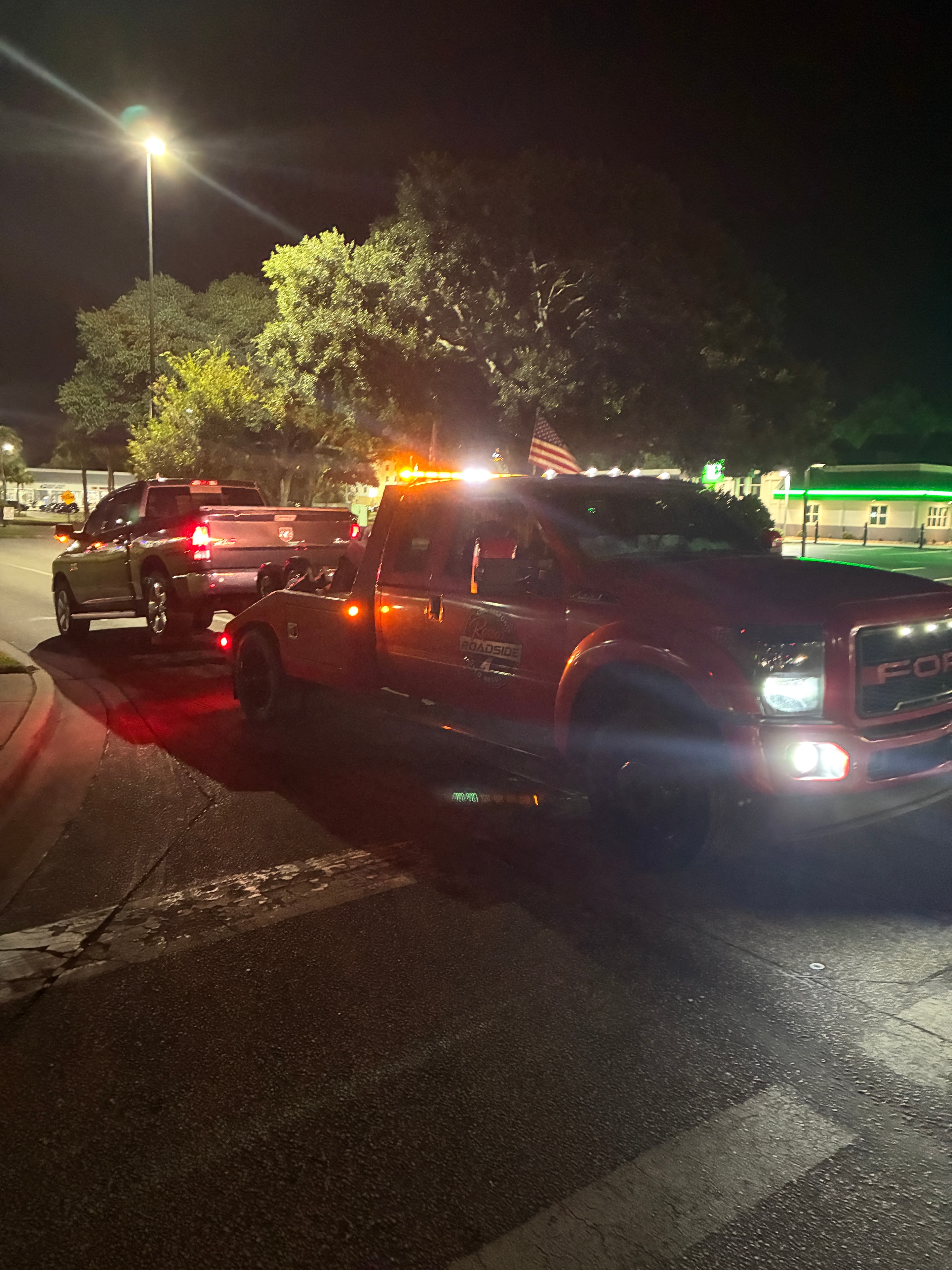 Tow truck towing vehicle at night